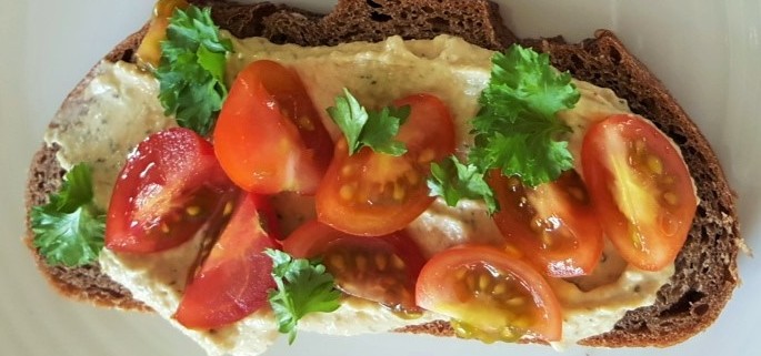 Tomatoes on rye bread with hummus
