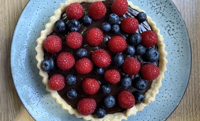 rich chocolate tart with raspberries and blueberries